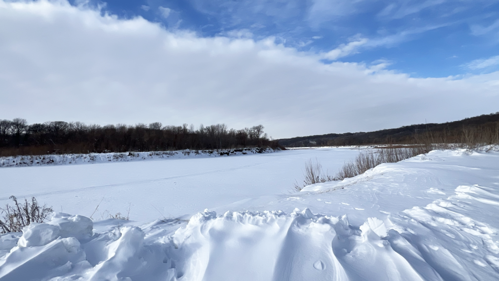 Pretty view of the snow covered river with a wedge of white clouds to the west